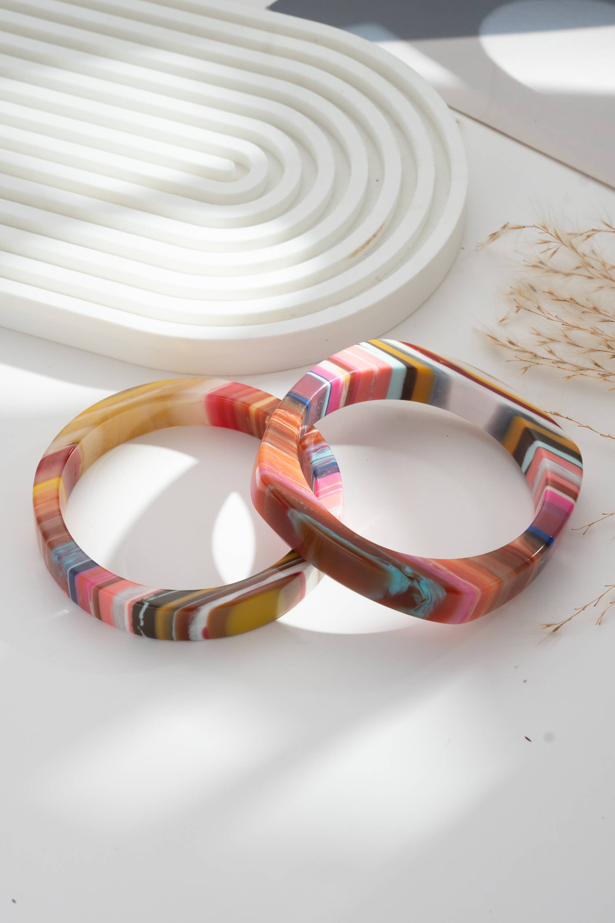 Set of two chic multicolored resin bracelets, round and rectangular